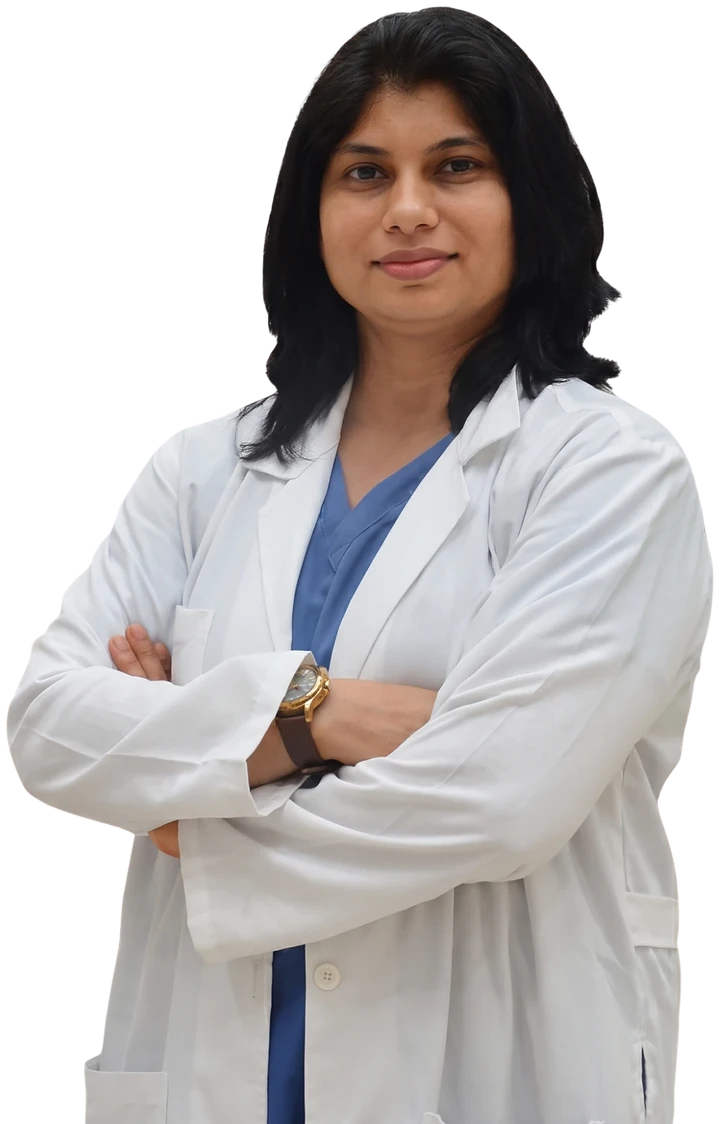 Dr. Neema Bhat in a white coat over blue scrubs
